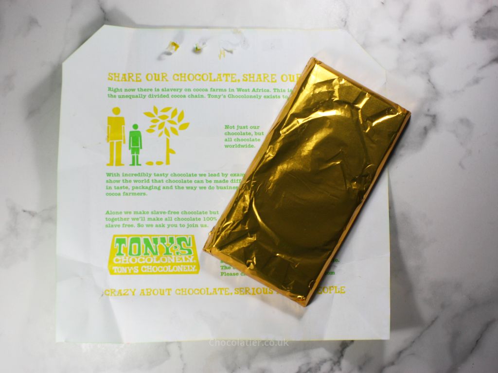 Beneath the wrapper of Tony's Chocolonely Lemon Meringue Easter Milk Chocolate Bar